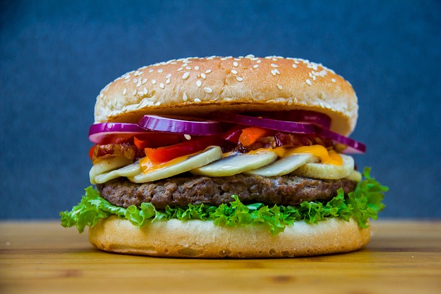Soczysty hamburger z wołowiną, sałatą, pomidorem i serem, podawany w świeżej bułce. Idealny na szybki lunch lub kolację.