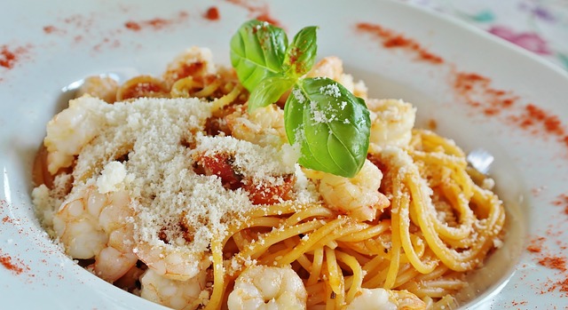 Makaron spaghetti w aromatycznym sosie pomidorowym, posypany świeżo startym parmezanem i bazylią. Idealny dla miłośników włoskiej kuchni.