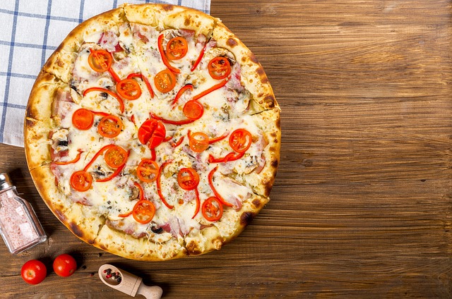 Pizza z chrupiącym ciastem, mozzarellą, pomidorami, bazylią i oliwą z oliwek, serwowana na gorąco prosto z pieca.